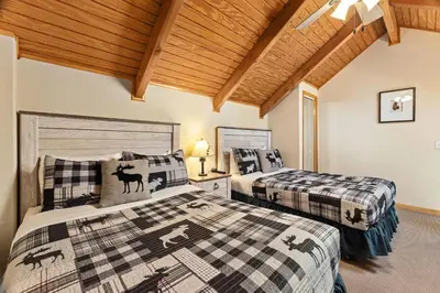 a bedroom with two beds and a wooden ceiling at Creekside Suites 03 by Estes Park Condos in Estes Park