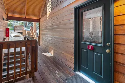 a wooden house with a green door on a deck at Creekside Suites 09 by Estes Park Condos in Estes Park