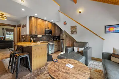 a kitchen and living room with a table and a couch at Creekside Suites 09 by Estes Park Condos in Estes Park