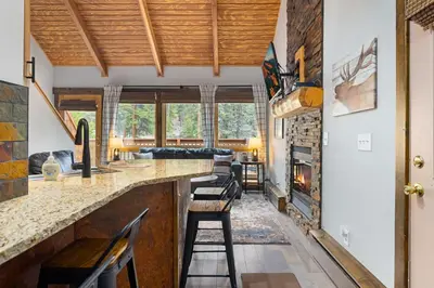 a kitchen with a bar and a fireplace at Creekside Suites 09 by Estes Park Condos in Estes Park
