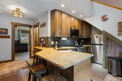 a kitchen with wooden cabinets and a counter top at Creekside Suites 09 by Estes Park Condos in Estes Park