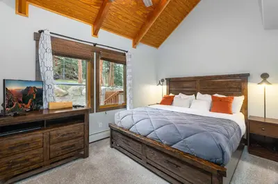 a bedroom with a bed and a tv and a window at Creekside Suites 09 by Estes Park Condos in Estes Park