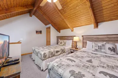 a bedroom with two beds and a tv at Creekside Suites 20 by Estes Park Condos in Estes Park