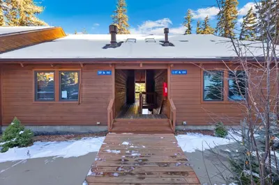 a wooden house with a snow covered roof at Creekside Suites 20 by Estes Park Condos in Estes Park