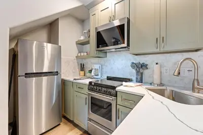 a kitchen with white cabinets and a stainless steel refrigerator at Creekside Suites 20 by Estes Park Condos in Estes Park