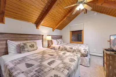 a bedroom with two beds and a ceiling fan at Creekside Suites 20 by Estes Park Condos in Estes Park
