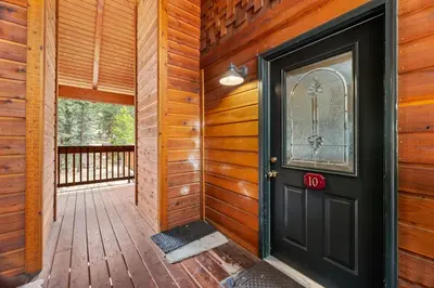 a wooden hallway with a black door on a deck at Creekside Suites 10 by Estes Park Condos in Estes Park