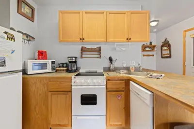 a kitchen with a white stove top oven next to a sink at Creekside Suites 10 by Estes Park Condos in Estes Park