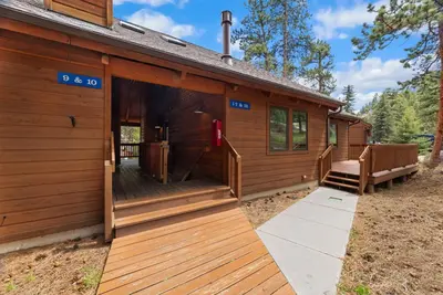 a large wooden cabin with a large deck at Creekside Suites 10 by Estes Park Condos in Estes Park