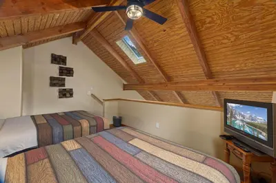 a bedroom with two beds and a flat screen tv at Creekside Suites 11 by Estes Park Condos in Estes Park