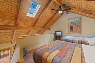 a bedroom with two beds and a ceiling fan at Creekside Suites 11 by Estes Park Condos in Estes Park