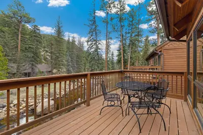 a patio with a table and chairs on a deck at Creekside Suites 11 by Estes Park Condos in Estes Park