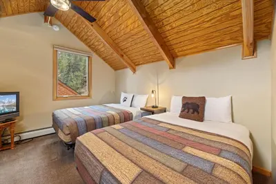 a bedroom with two beds and a tv in it at Creekside Suites 11 by Estes Park Condos in Estes Park