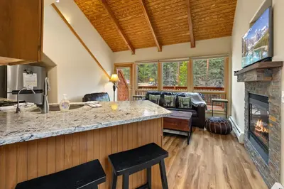 a kitchen and living room with a fireplace at Creekside Suites 11 by Estes Park Condos in Estes Park