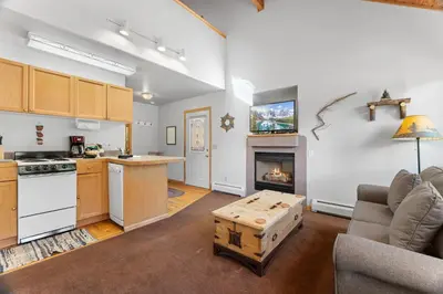 a kitchen and a living room with a fireplace at Creekside Suites 18 by Estes Park Condos in Estes Park