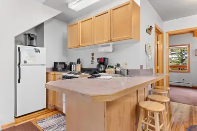 a kitchen with wooden cabinets and a counter top at Creekside Suites 18 by Estes Park Condos in Estes Park