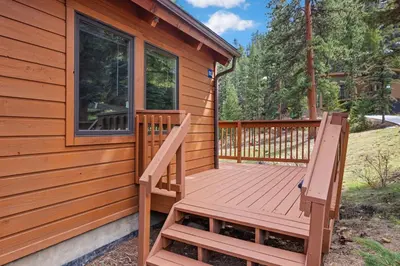 a deck with two chairs on the side of a cabin at Creekside Suites 21 by Estes Park Condos in Estes Park