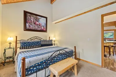 a bedroom with a bed and a bench in it at Creekside Suites 21 by Estes Park Condos in Estes Park