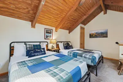 two beds in a room with wooden ceilings at Creekside Suites 21 by Estes Park Condos in Estes Park