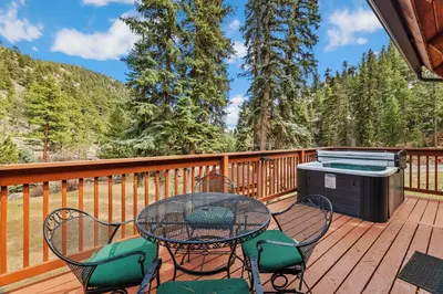 a patio with a table and chairs on a deck at Creekside Suites 21 by Estes Park Condos in Estes Park