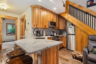 a kitchen with wooden cabinets and a counter top at Creekside Suites 21 by Estes Park Condos in Estes Park