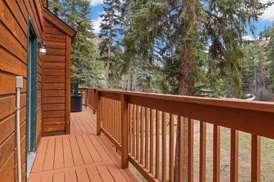 a wrap around deck on a cabin in the woods at Creekside Suites 21 by Estes Park Condos in Estes Park