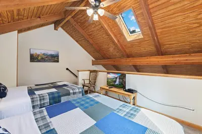 two beds in a room with a wooden ceiling at Creekside Suites 21 by Estes Park Condos in Estes Park