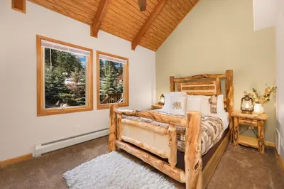 a bedroom with a wooden bed and a window at Creekside Suites 19 by Estes Park Condos in Estes Park
