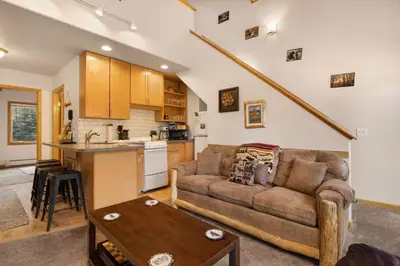 a living room with a couch and a table at Creekside Suites 19 by Estes Park Condos in Estes Park