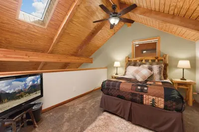 a bedroom with a bed and a ceiling fan at Creekside Suites 19 by Estes Park Condos in Estes Park