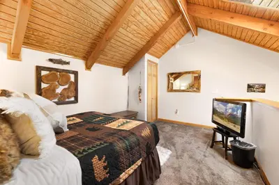 a bedroom with a bed and a flat screen tv at Creekside Suites 19 by Estes Park Condos in Estes Park