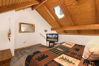 a bedroom with a king sized bed and a television at Creekside Suites 19 by Estes Park Condos in Estes Park