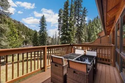 a deck with a table and chairs on a house at Creekside Suites 19 by Estes Park Condos in Estes Park