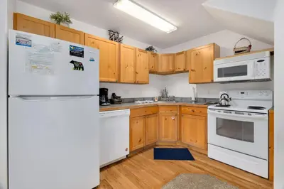 a kitchen with white appliances and wooden cabinets at Bugle Pointe B23 by Estes Park Condos in Estes Park