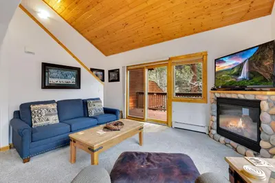 a living room with a blue couch and a fireplace at Bugle Pointe B23 by Estes Park Condos in Estes Park
