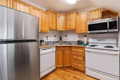a kitchen with wooden cabinets and stainless steel appliances at Bugle Pointe A08 by Estes Park Condos in Estes Park