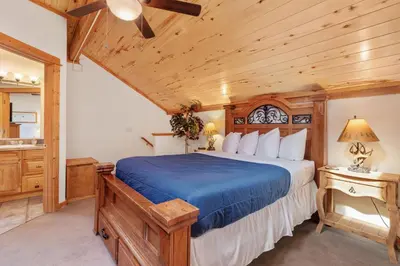 a bedroom with a bed and a wooden ceiling at Bugle Pointe A08 by Estes Park Condos in Estes Park