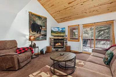 a living room with a couch and a fireplace at Bugle Pointe A10 by Estes Park Condos in Estes Park