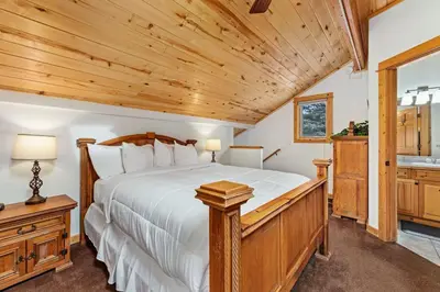 a bedroom with a large bed and a wooden ceiling at Bugle Pointe A10 by Estes Park Condos in Estes Park