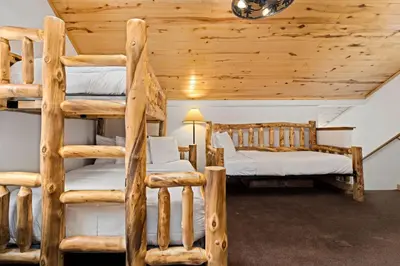a bedroom with two bunk beds in a log cabin at Bugle Pointe A10 by Estes Park Condos in Estes Park