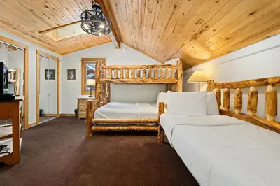 two beds in a room with wooden ceilings at Bugle Pointe A10 by Estes Park Condos in Estes Park