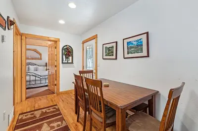 a dining room with a table and chairs and a bedroom at Bugle Pointe A10 by Estes Park Condos in Estes Park