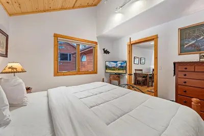 a bedroom with a large white bed and a television at Bugle Pointe A10 by Estes Park Condos in Estes Park