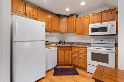 a kitchen with white appliances and wooden cabinets at Bugle Pointe A11 by Estes Park Condos in Estes Park