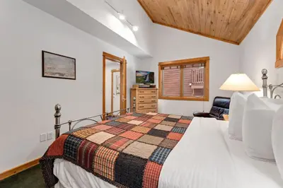 a bedroom with a bed and a chair in a room at Bugle Pointe A11 by Estes Park Condos in Estes Park