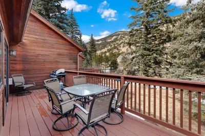 a patio with a table and chairs on a deck at Bugle Pointe A11 by Estes Park Condos in Estes Park