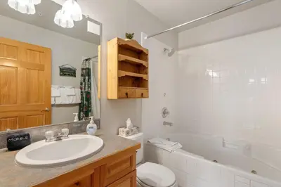 a bathroom with a sink and a toilet and a tub at Bugle Pointe A12 by Estes Park Condos in Estes Park