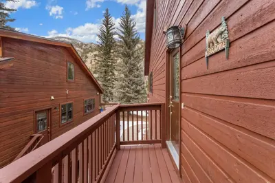 a wooden walkway leading to a balcony on a red building at Bugle Pointe A12 by Estes Park Condos in Estes Park