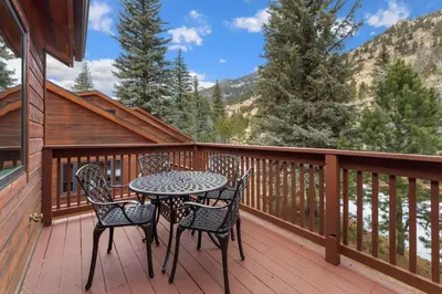 a table and chairs on the deck of a cabin at Bugle Pointe A12 by Estes Park Condos in Estes Park
