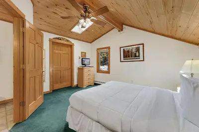 a bedroom with a white bed and a wooden ceiling at Bugle Pointe A14 by Estes Park Condos in Estes Park